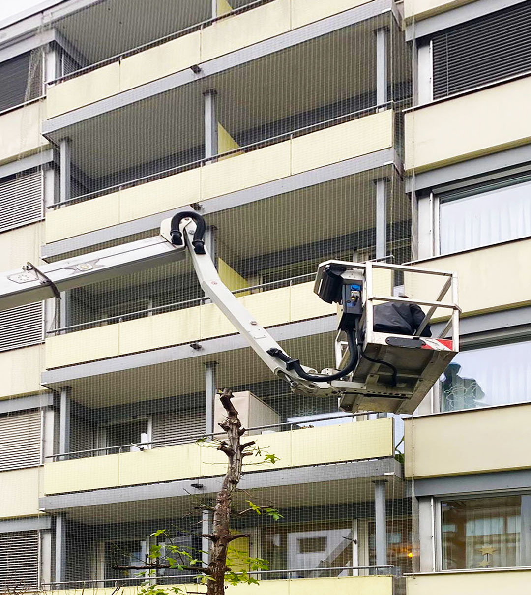 Hubarbeitsbühne bei Arbeiten an Balkonen eines Mehrfamilienhauses
