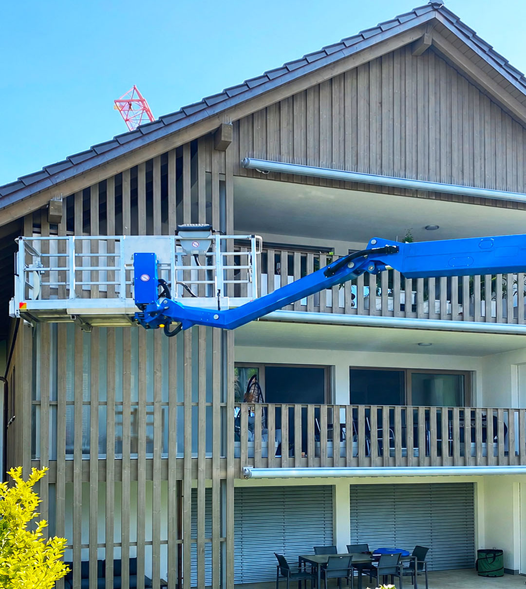 Hubarbeitsbühne bei Arbeiten an Dachuntersicht und Fassade eines Wohnhauses