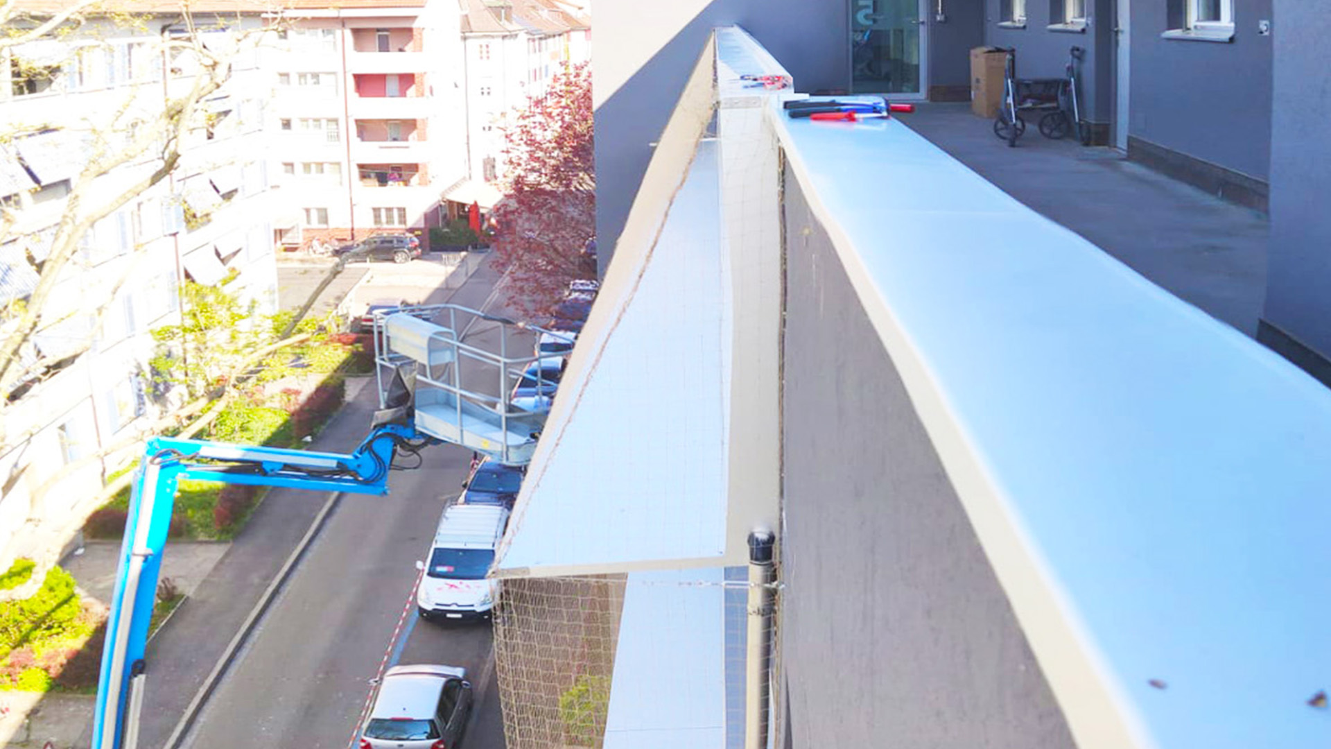 Montagearbeiten mit Hebebühne an Fassade und Dachkante für die professionelle Vogelabwehr in Bülach