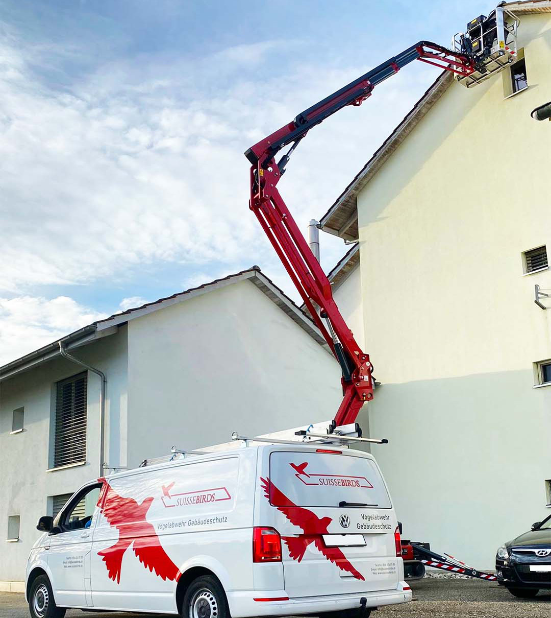 Suisse Birds Servicefahrzeuge und Gelenkarbeitsbühne bei Arbeiten an einem Wohngebäude