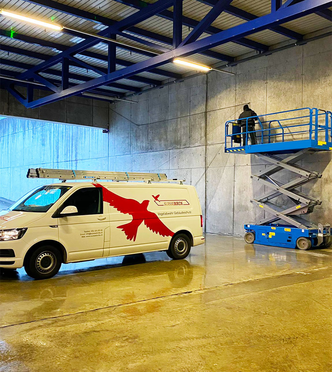Suisse Birds Servicefahrzeug und Scherenarbeitsbühne in einer Industriehalle