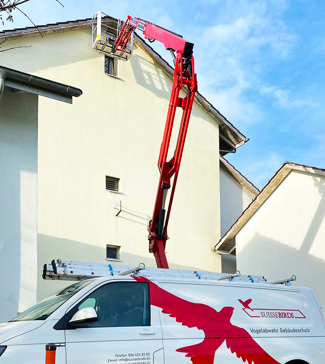 Suisse Birds Servicefahrzeug und Gelenkarbeitsbühne bei Arbeiten an einem Wohngebäude