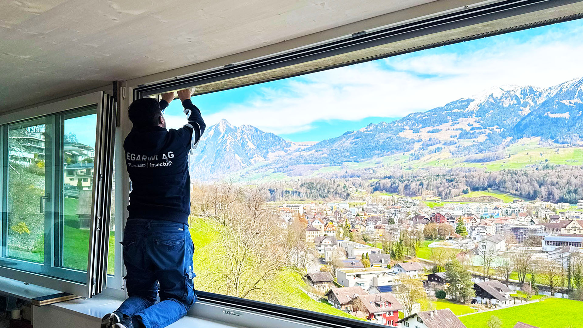 Mitarbeiter bei Arbeiten an einem Storenkasten beziehungsweise Fensterbereich für die Vogelabwehr in Liestal