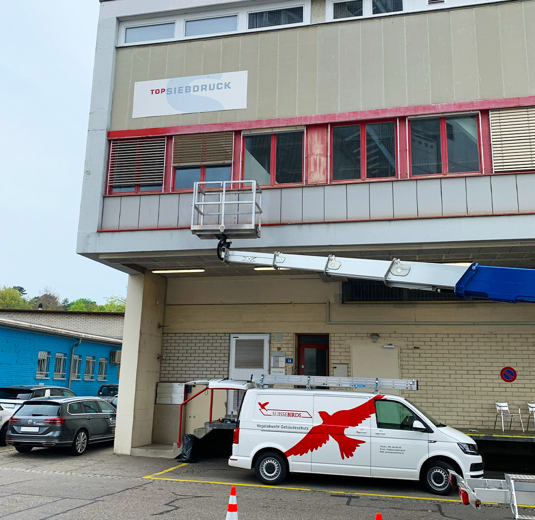 Suisse-Birds-Fahrzeug und Arbeitsbühne an einer Gewerbehalle