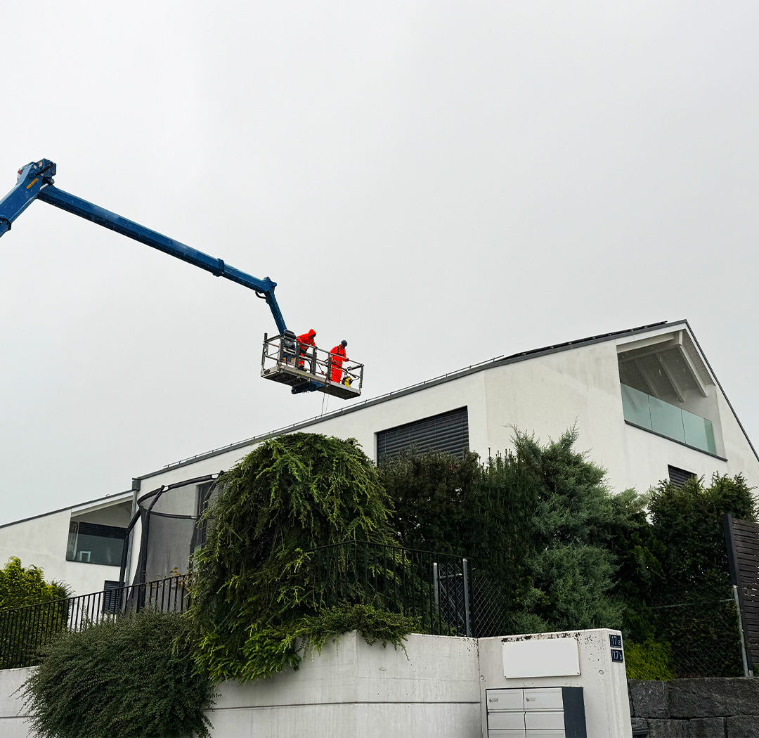 Hubarbeitsbühne bei Arbeiten am Dach eines modernen Wohngebäudes