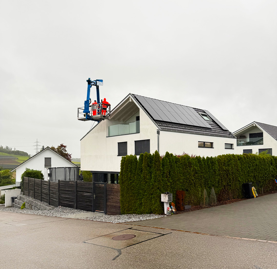 Hubarbeitsbühne bei Arbeiten an Dach und Fassade eines modernen Wohnhauses