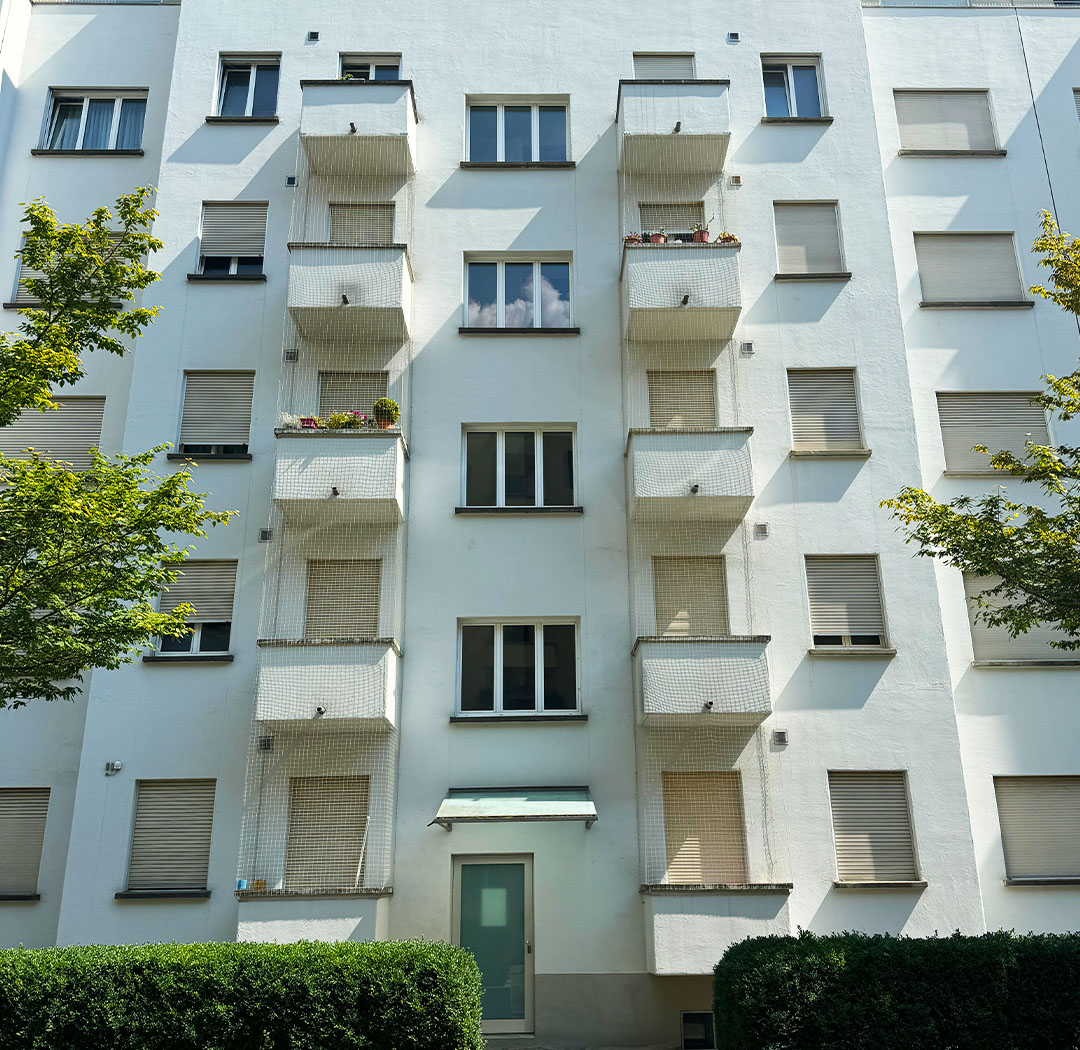 Mehrgeschossiges Wohngebäude mit wiederkehrenden Balkonen und Fassadennischen