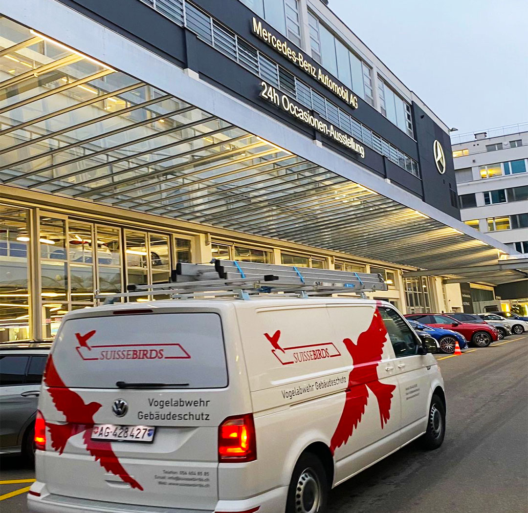 Suisse-Birds-Fahrzeug vor einem grossen Gewerbe- und Dienstleistungsgebäude