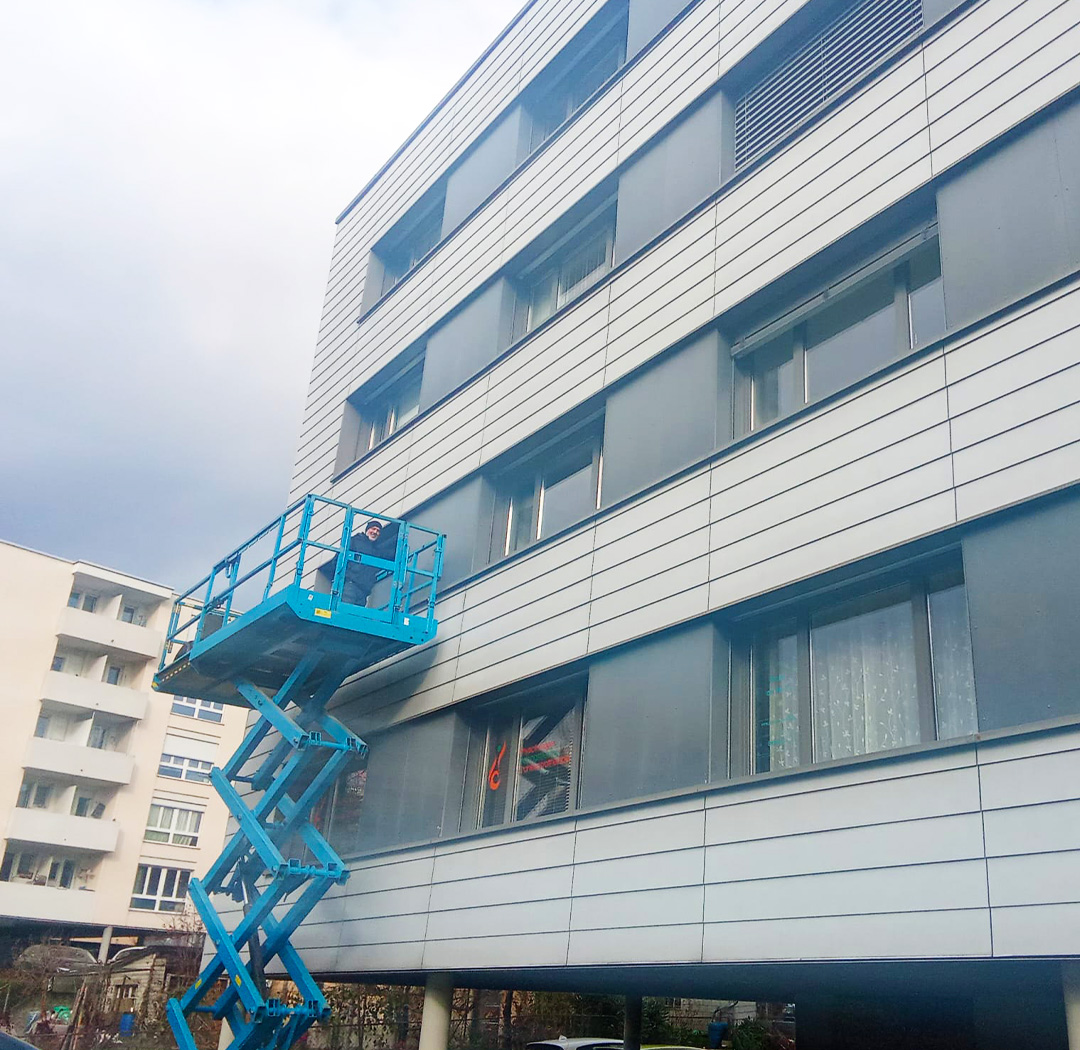 Scherenarbeitsbühne bei Arbeiten an einer mehrgeschossigen Gewerbefassade