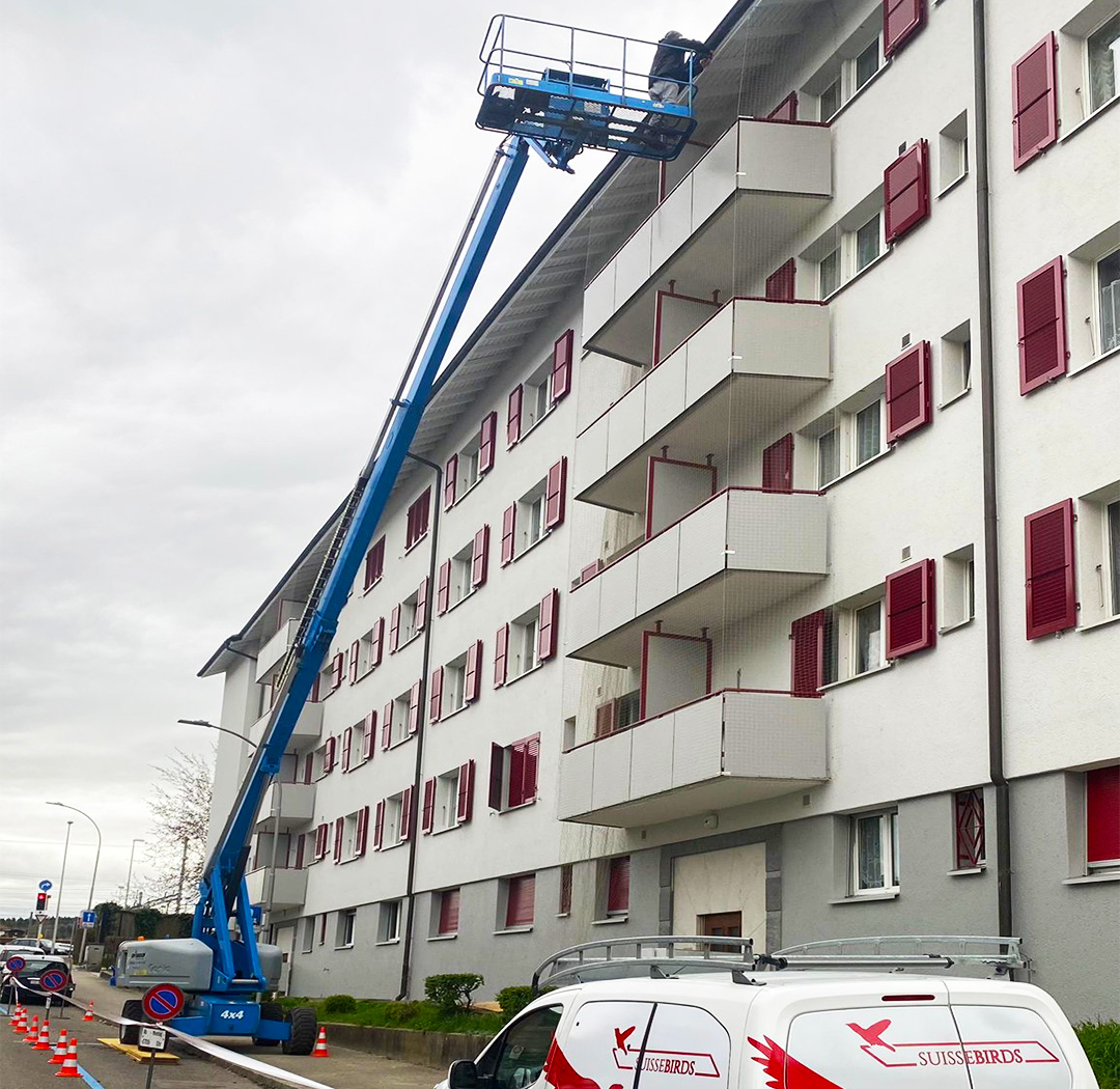 Hubarbeitsbühne bei Arbeiten an der Fassade eines langen Mehrfamilienhauses