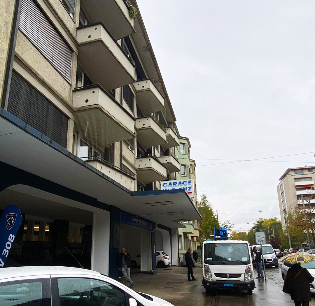 Suisse-Birds-Fahrzeug vor einem mehrgeschossigen Stadtgebäude