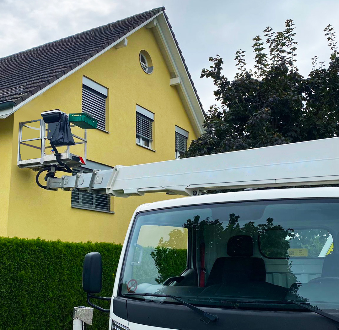 Arbeitsbühne bei Arbeiten an der Fassade eines Wohnhauses