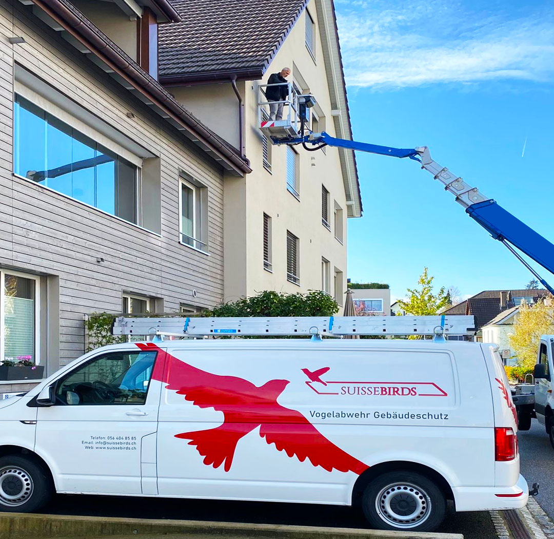 Suisse-Birds-Fahrzeug und Hebebühne bei Arbeiten an einem Wohngebäude