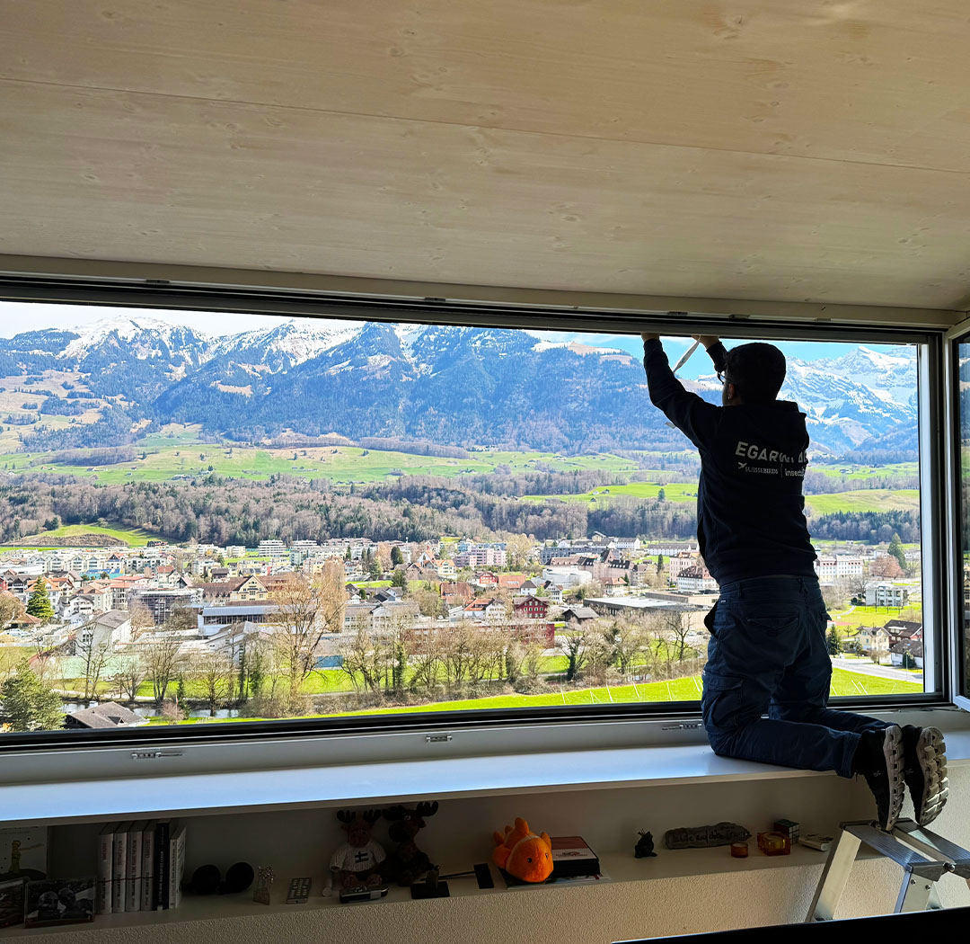Mitarbeiter bei der Montage eines Vogelschutzes an einem Storenkasten