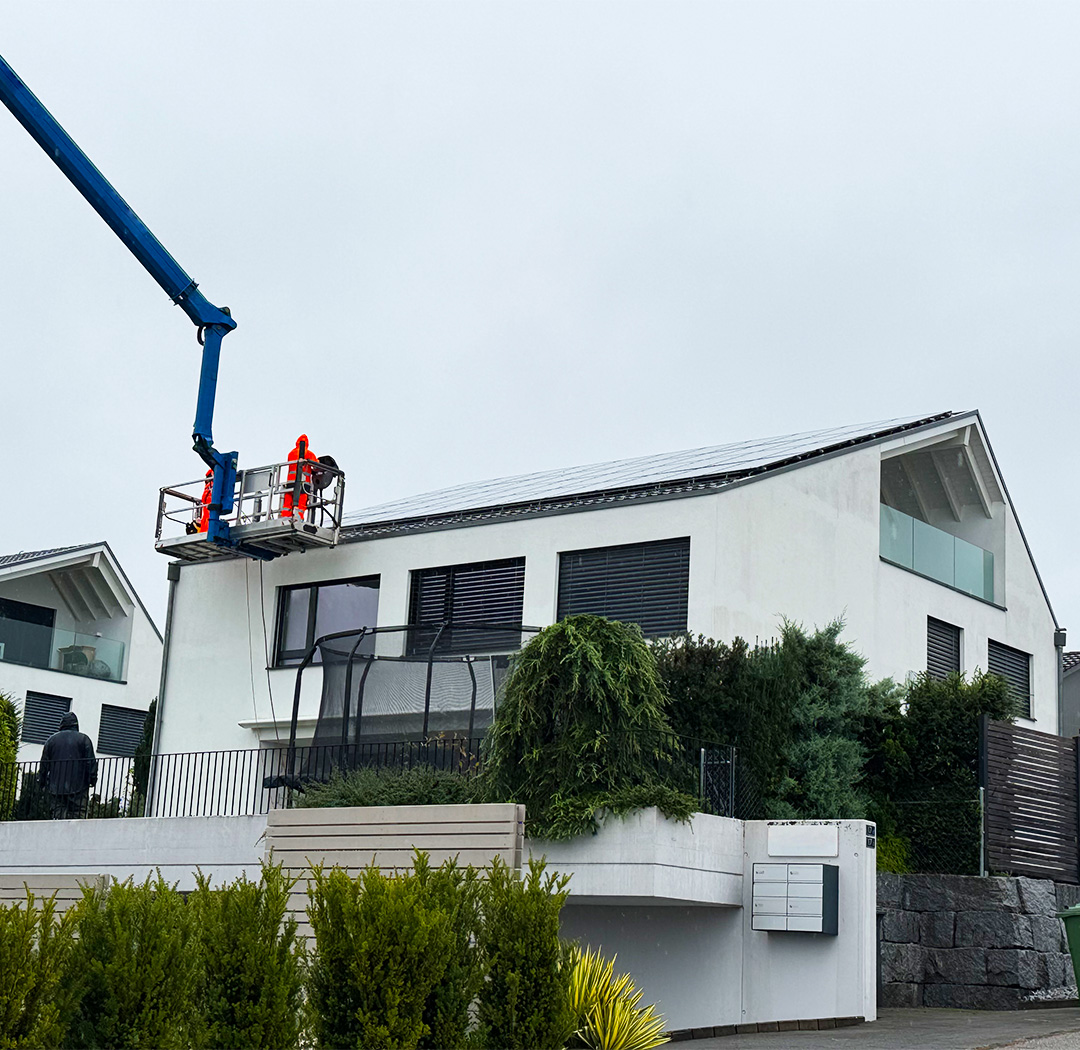 Hubarbeitsbühne bei Arbeiten an der Fassade eines modernen Wohnhauses