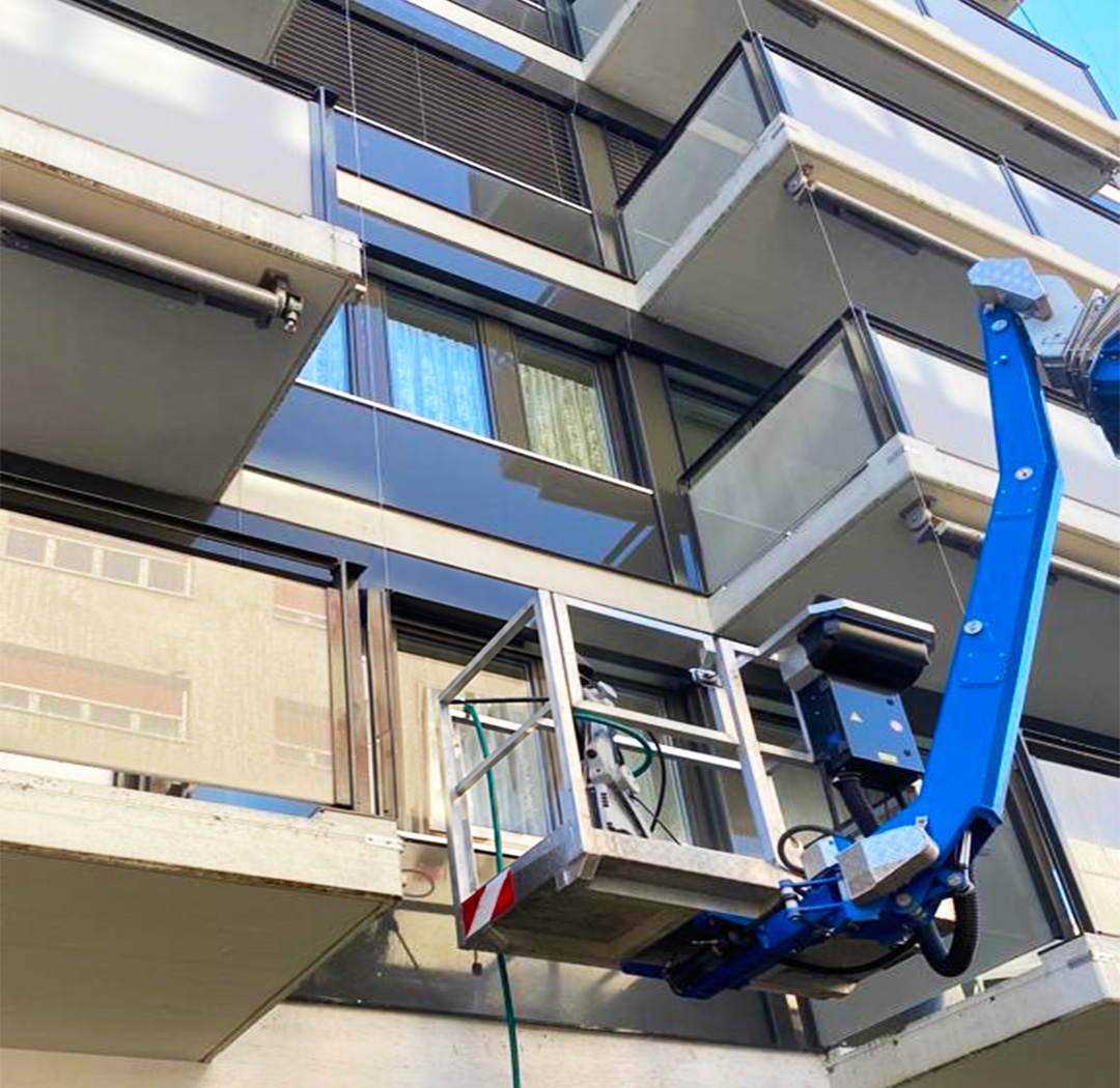 Arbeitsbühne bei Arbeiten an einem Balkon eines Mehrfamilienhauses