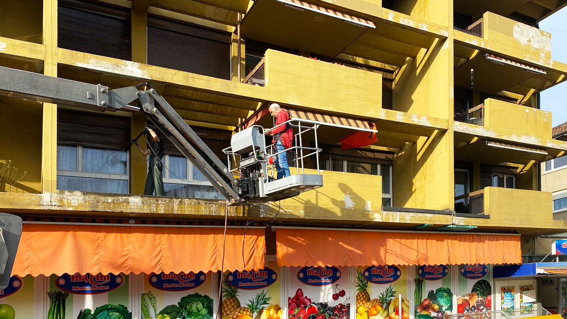 Montagearbeiten mit Hebebühne an Fassade und Dachkante für die professionelle Vogelabwehr in Zürich